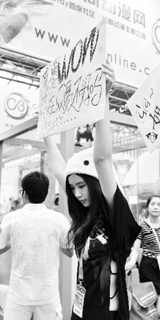 在ChinaJoy展会上举牌对魔兽表示关切的女孩。用现在流行的话说,这位MM举的不是牌子,是寂寞。张劼 摄 WOW之争